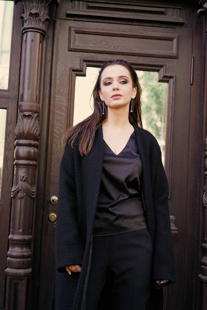 Gorgeous young brunette woman in black clothes posing on the street  - Φωτογραφία, εικόνα