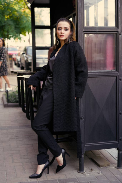 Nádherná mladá brunetka žena v černých šatech, které představují  - Fotografie, Obrázek