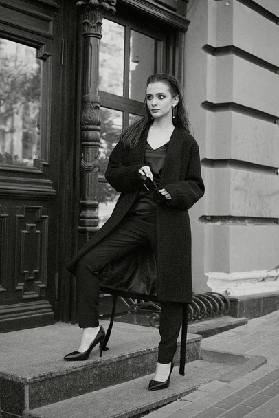 Gorgeous young brunette woman in black clothes posing on the street  - Fotografie, Obrázek