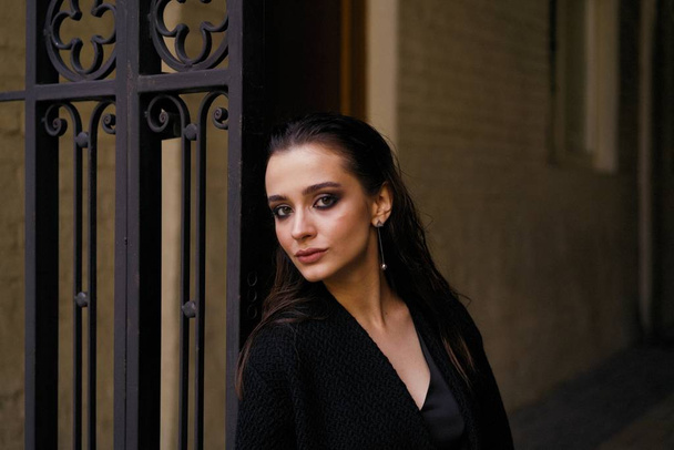 Gorgeous young brunette woman in black clothes posing on the street  - Φωτογραφία, εικόνα
