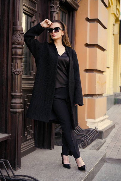 Gorgeous young brunette woman in black clothes posing on the street  - Foto, Imagem