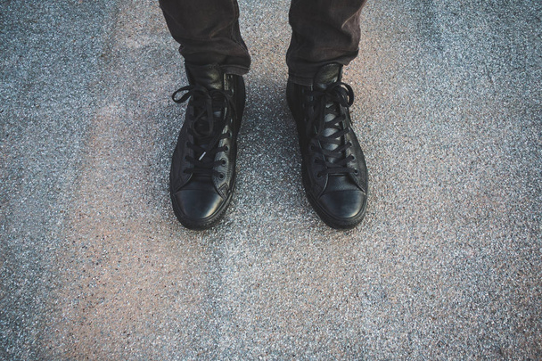 Siyah ayakta dokulu bir yere giyen bir kişinin düşük bölümü - Fotoğraf, Görsel