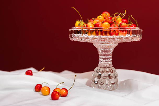 Delightful cherries on white and red background with copy space - Fotó, kép