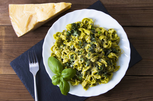 prato de macarrão italiano preparado com queijo, legumes e folha de manjericão
 - Foto, Imagem