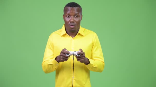 Young happy African businessman playing games and winning - Imágenes, Vídeo