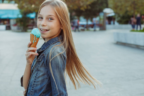 Aranyos és vidám fiatal lány eszik fagylaltot kívül - Fotó, kép