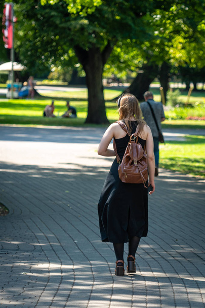 Girl with a backpack walking along the city park. - Foto, Bild