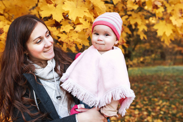 Gelukkige familie op herfstwandeling. Moeder en dochtertje wandelen in het Park en genieten van de prachtige natuur van de herfst. - Foto, afbeelding