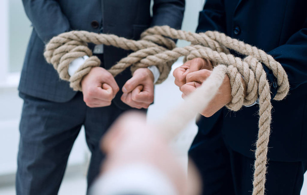close up.businessman pulls a business team on a rope - 写真・画像