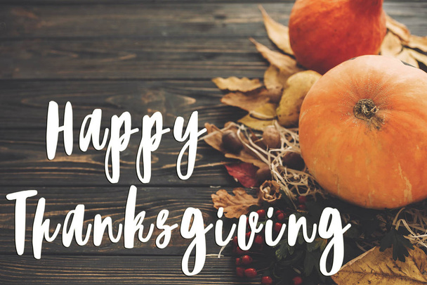 Happy Thanksgiving tekst na piękną kompozycję z dyni, jesienne warzywa, kolorowe liście, żołędzie, orzechy, jagody na drewnianym stole rustykalny. Kartkę z życzeniami sezon - Zdjęcie, obraz