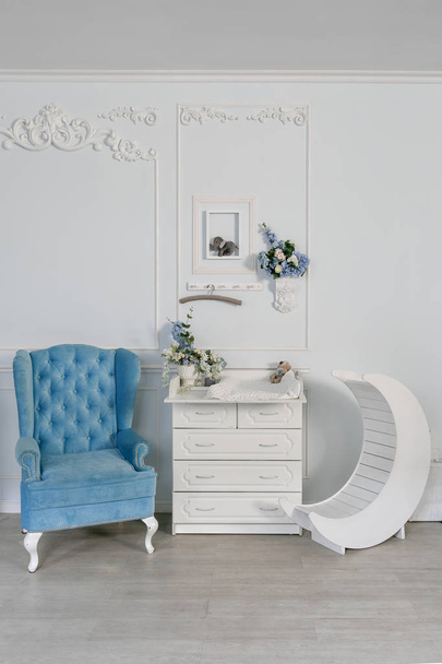 Cadeira azul e mesa de vestir para bebês. interior de um quarto espaçoso para crianças
. - Foto, Imagem