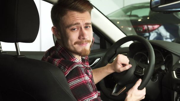 Atrakcyjny, brodaty mężczyzna uśmiecha się do kamery na ramieniu, siedząc w nowy samochód - Zdjęcie, obraz