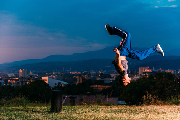 Człowiek wykonuje skok freerunning w parku - Zdjęcie, obraz