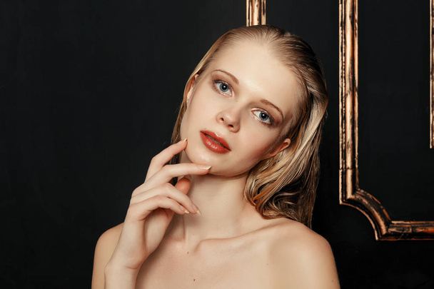 Beauty fashion model girl natural makeup wet hair on black gold background in warm tones. Portrait of young woman with fashion makeup - 写真・画像