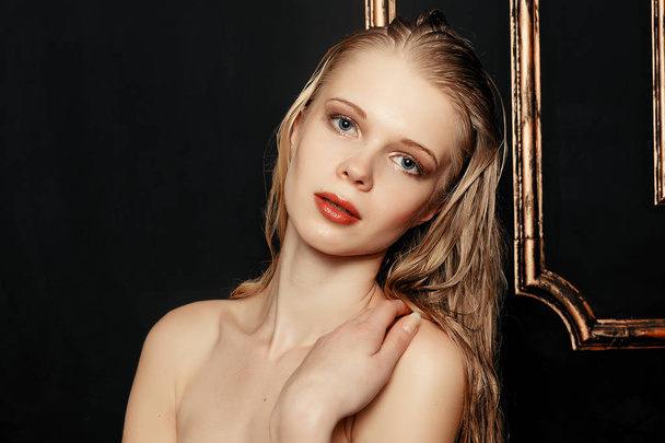 Beauty fashion model girl natural makeup wet hair on black gold background in warm tones. Portrait of young woman with fashion makeup - Photo, image