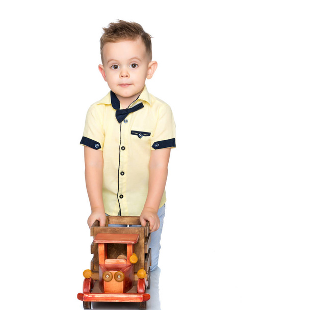 A little boy is playing with a toy car. - Fotó, kép