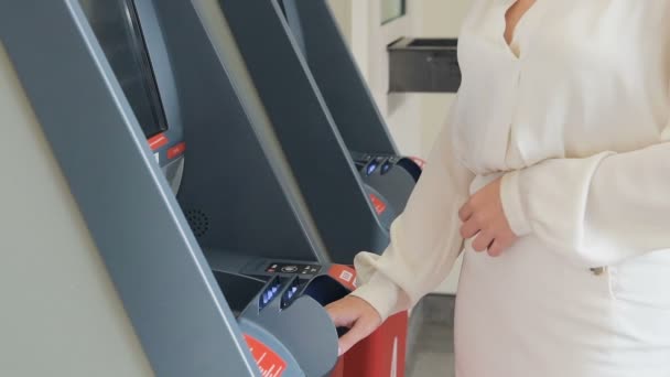 Mujer joven ingresando código PIN en el cajero automático de la ciudad en cámara lenta
 - Metraje, vídeo