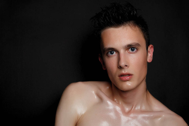 Handsome young man isolated. Beauty portrait of shirtless muscular man is standing on black background and looking at camera. Men's health. - Foto, Bild