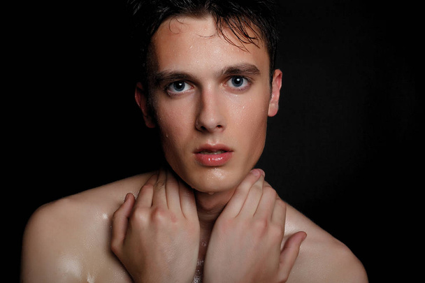 Handsome young man isolated. Beauty portrait of shirtless muscular man is standing on black background and looking at camera. Men's health. - Foto, afbeelding