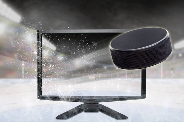 Hockey puck flying out of shattering TV screen in stadium with copy space. Concept of realistic 3D or 4D sports TV, virtual reality VR or computer gaming. - Photo, Image
