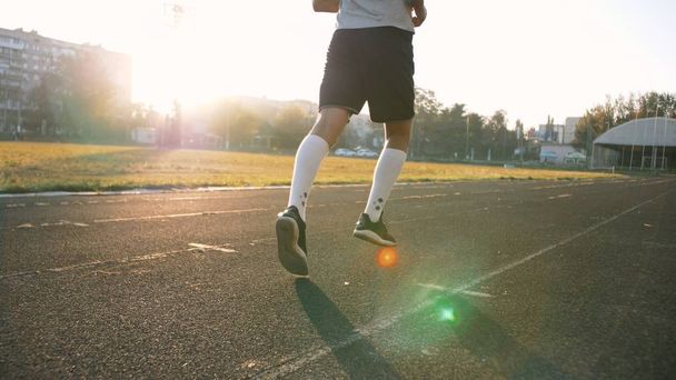 Mieszanej rasy lekkoatleta biegacz stopy w białe skarpetki działa na bieżni zbliżenie na buty - Zdjęcie, obraz