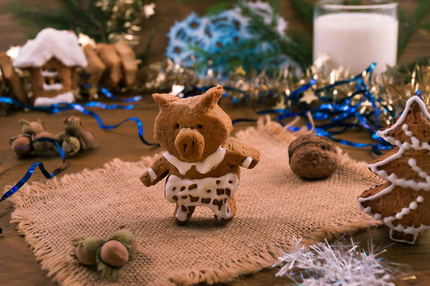 Christmas cookies in the form of a funny pig-the symbol of 2019 from short pastry covered with sugar glaze. - Photo, Image