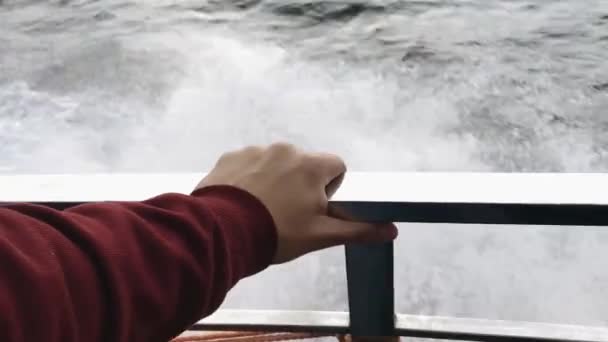 Hand van een man op de leuning van een jacht tegen de achtergrond van zeewater. Slow motion. - Video