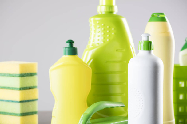 House and office cleaning up theme.  Set of different colorful cleaning products in bottles and sponges and brush on gray background. - Fotó, kép
