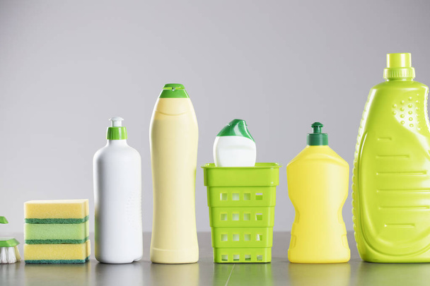 Ház és iroda takarítás megjelöl téma. A különböző színes takarítás termékek-palackok és a szivacsok és a szürke háttér kefe készlet. - Fotó, kép