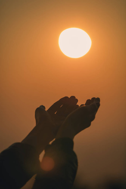 Προσεύχεται τα χέρια του κοριτσιού στο ηλιοβασίλεμα / Ανατολή του ηλίου με θάλασσα / Ωκεανός backround. - Φωτογραφία, εικόνα