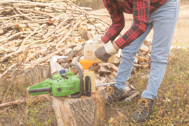 Winter is coming - lumberjack maintaining chainsaw outdoors. - Photo, Image