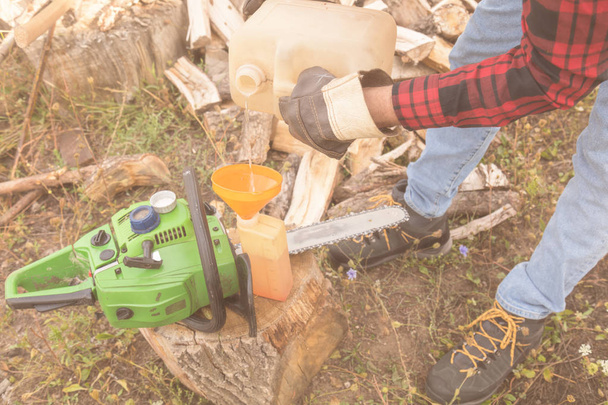 Winter is coming - lumberjack maintaining chainsaw outdoors. - Photo, Image