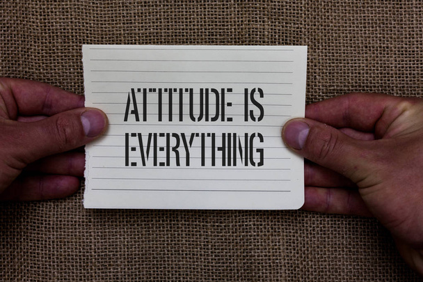 Text sign showing Attitude Is Everything. Conceptual photo Positive Outlook is the Guide to a Good Life Man holding piece notebook paper jute background Communicating ideas. - Photo, Image