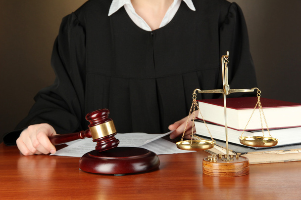 Judge sitting at table during court hearings on black background - Φωτογραφία, εικόνα
