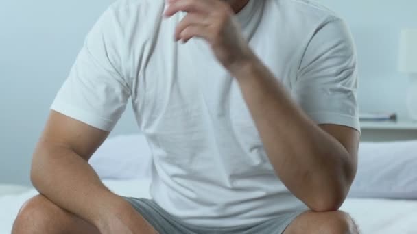 Sad thoughtful male sitting on bed, health problem, life difficulties, stress - Кадри, відео