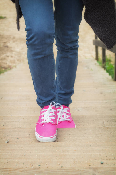 Pies femeninos en zapatillas rosadas mientras camina, vista de cerca
 - Foto, imagen
