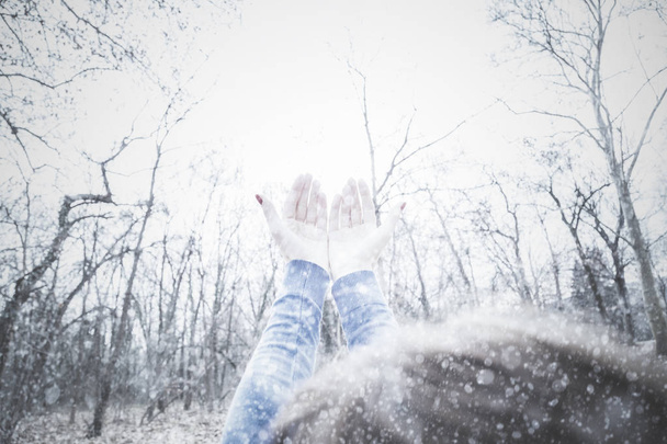 Το κορίτσι με τα χέρια στον αέρα περιμένοντας το πρώτο χιόνι της σεζόν. - Φωτογραφία, εικόνα