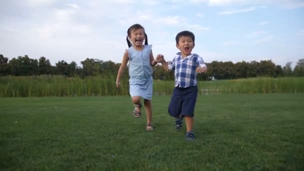 Örömteli ázsiai gyerekek fut össze a parkban - Felvétel, videó