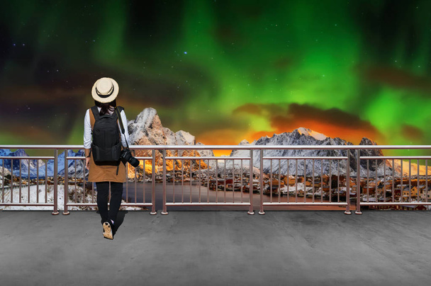 Turista femenina asiática, lleva un estilo casual Japanese.with simple mochila negra y cámara con lente detrás mirando paisaje vista de invierno en Noruega
. - Foto, Imagen