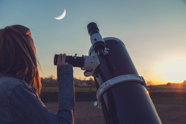 Ay bir teleskopa seyir kız. - Fotoğraf, Görsel