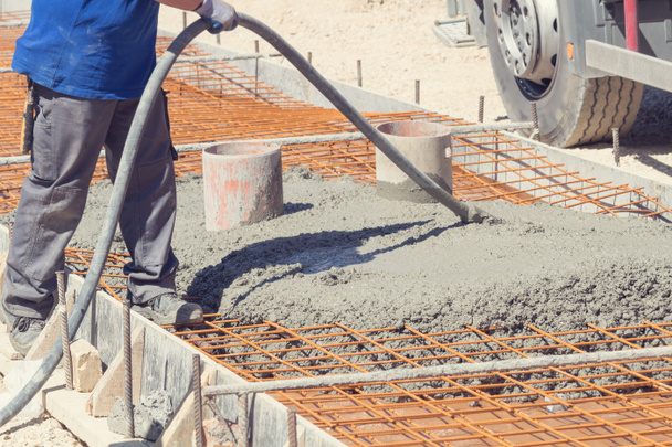 Construction worker leveling concrete pavement outdoors. - Photo, Image