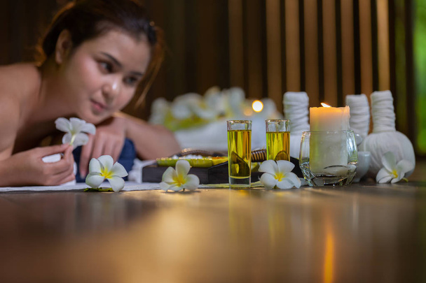 Young Asia beautiful woman during massage with spa herbal compress with oil and herbal set near site, relaxing and healthy concept. - Photo, Image