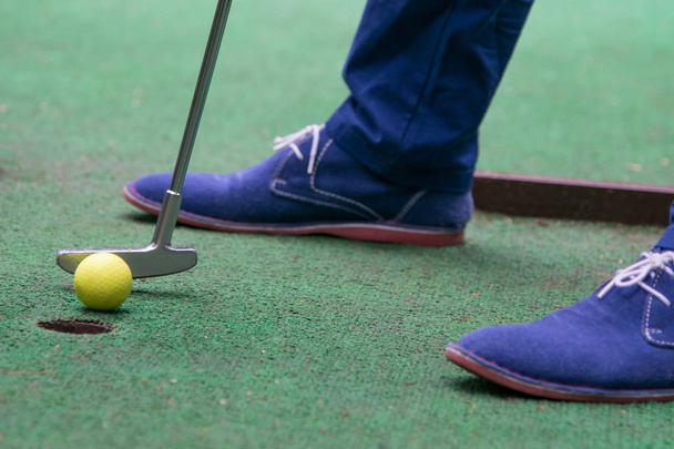 close-up, top view on grass background, mini golf ball and blue shoes - Foto, Imagem