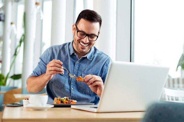 Cheerful businessman eating food in restaurant - Photo, Image