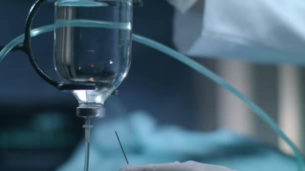 Medische hand steek de naald in de daling van de teller bij chirurgie werking. Therapie van de infusie. - Video