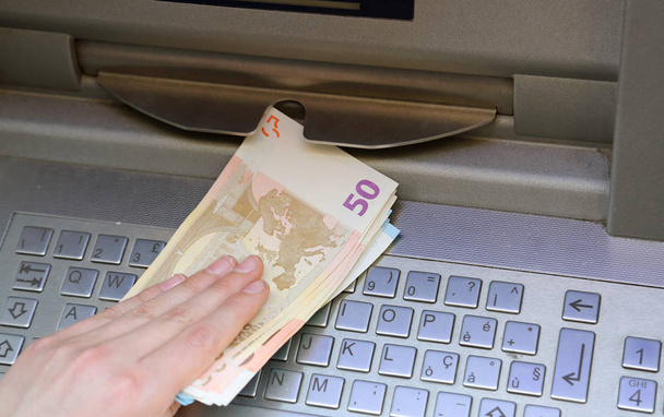 much money at an european ATM and the hand of a boy - Photo, Image