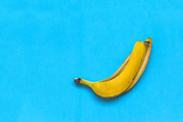 yellow skin of a banana against a blue background,  fruit - Foto, imagen