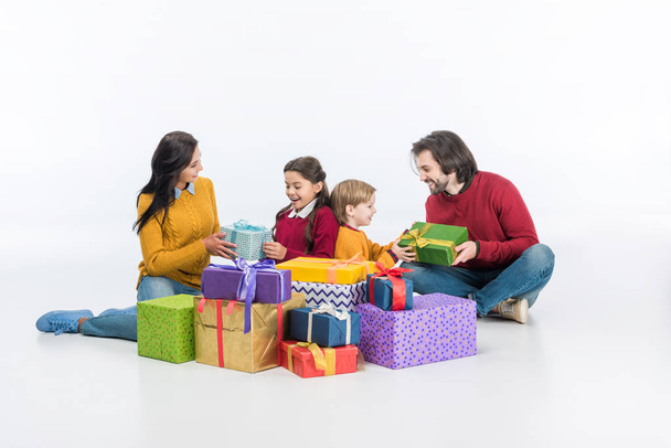 gelukkige ouders en kinderen met ingepakte geschenkdozen geïsoleerd op wit  - Foto, afbeelding