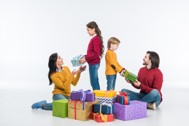 smiling family with wrapped presents isolated on white  - Foto, afbeelding