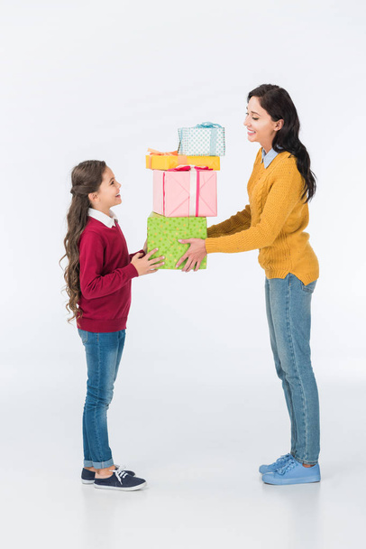 счастливая мать и дочь с обернутыми подарочные коробки изолированы на белом
  - Фото, изображение